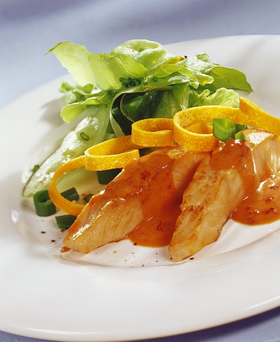 Salmon fillets with spicy sauce and salad