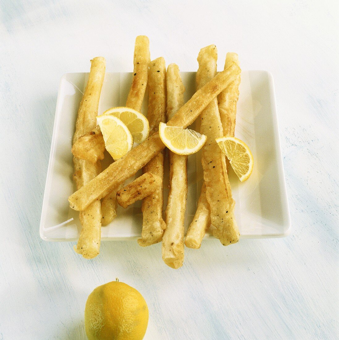 Fried scorzonera with lemon wedges