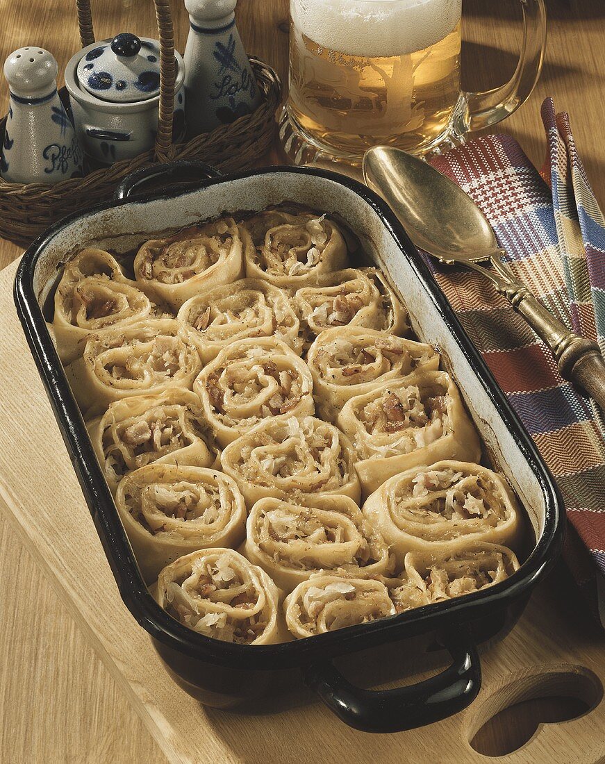 Pasta rolls with sauerkraut and bacon filling in baking dish
