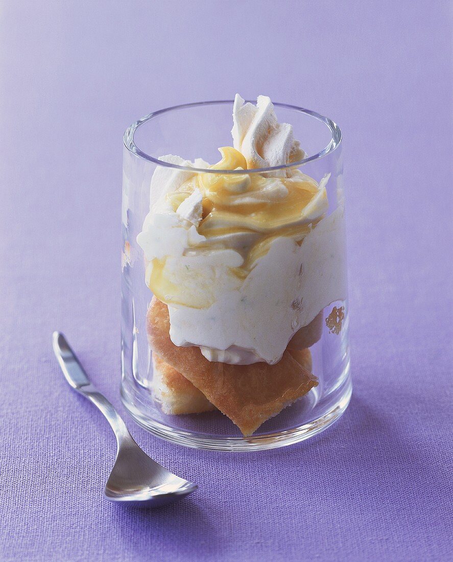 Lemon and lime trifle in glass on purple background