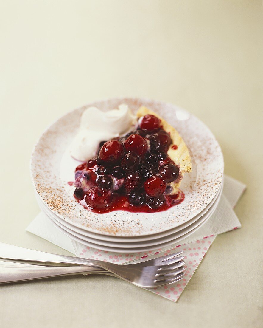 Stück Beeren-Kirschen-Tarte mit Sahne