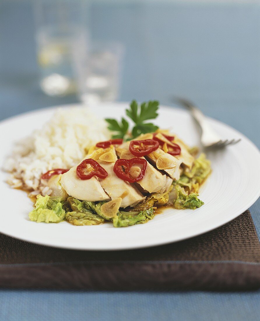 Poached chicken breast with chili rings, garlic and rice