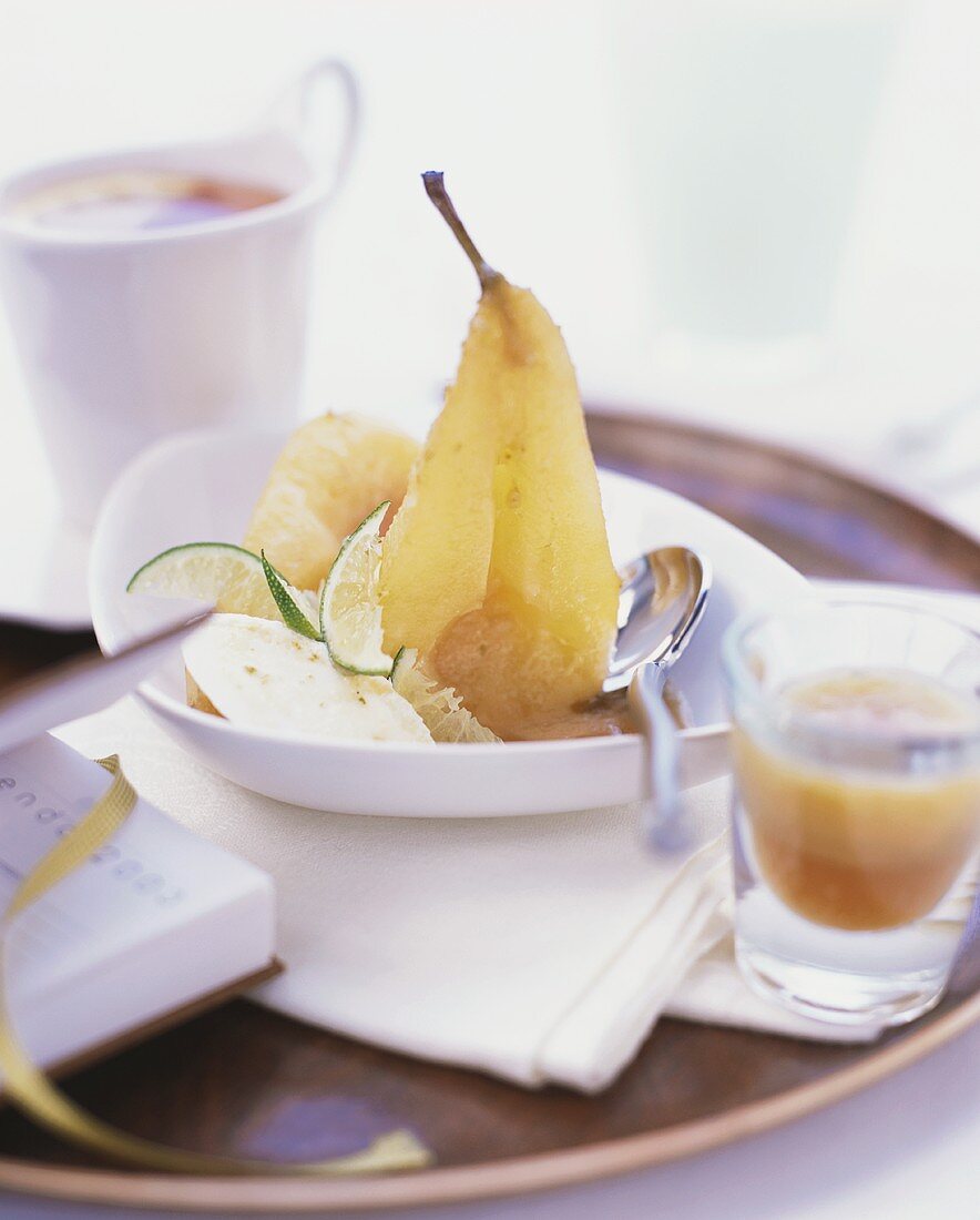 Pochierte Birne mit Eis und Limettenschnitzen