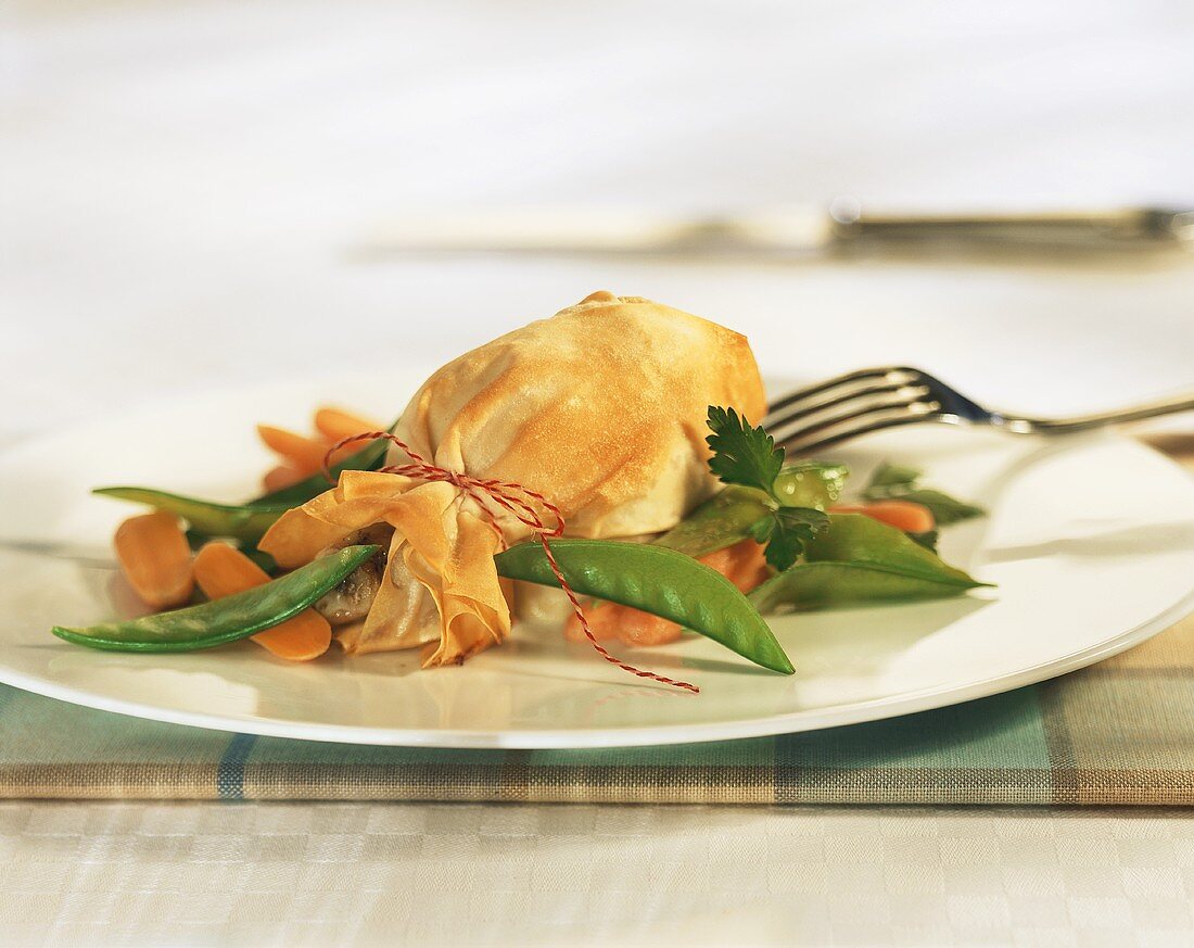 Chicken leg in strudel pastry with mangetout peas and carrots