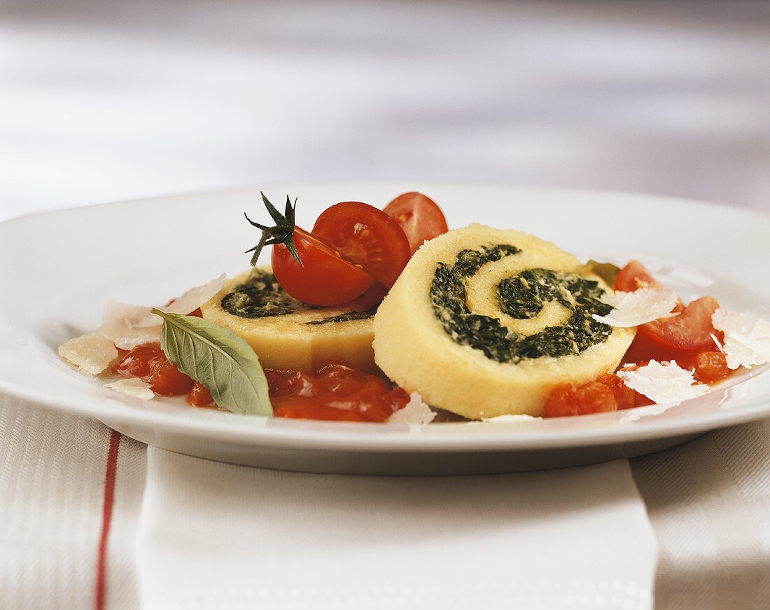 Polenta roulade with spinach filling in tomato sauce