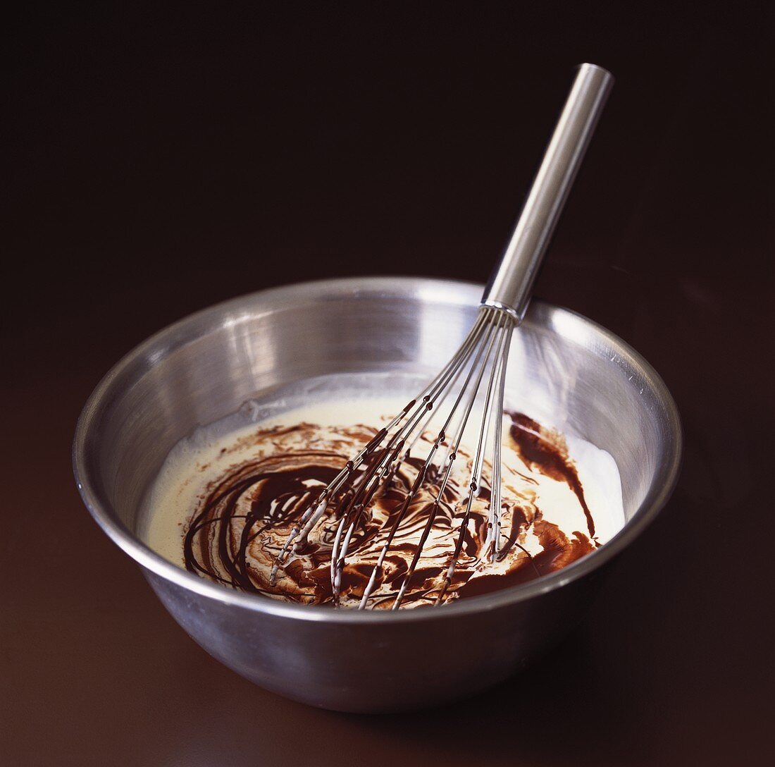 Mixing melted chocolate with cream