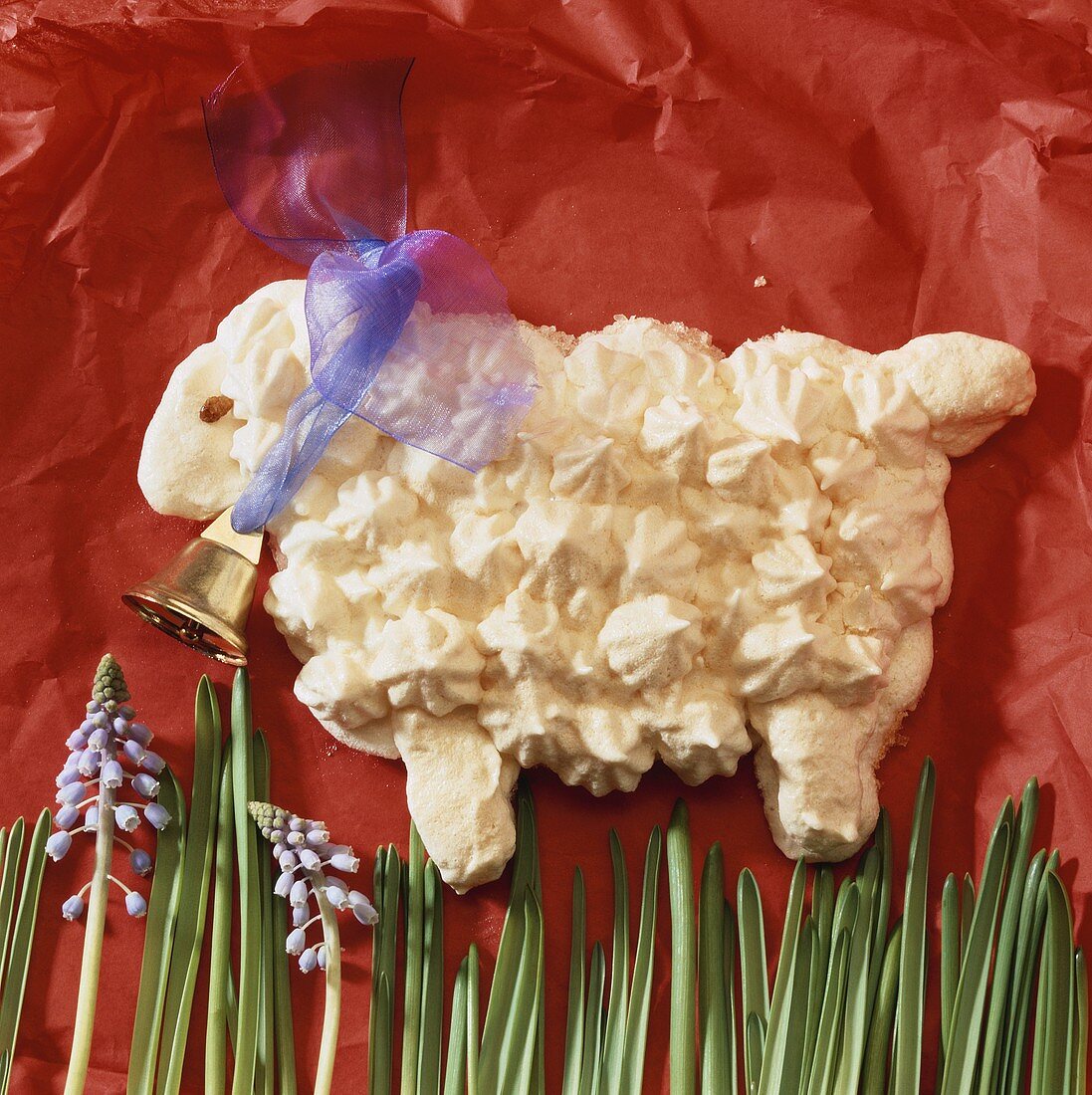 Sweet Easter lamb made of meringue with bow and bell