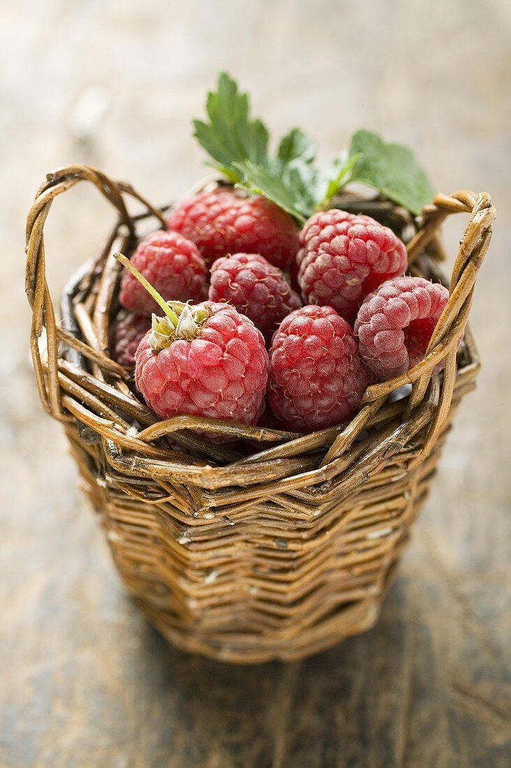 Rote Himbeeren in kleinem Korb