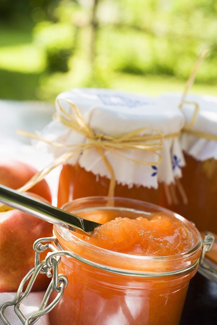 Nektarinenmarmelade in Gläsern auf Tisch im Freien