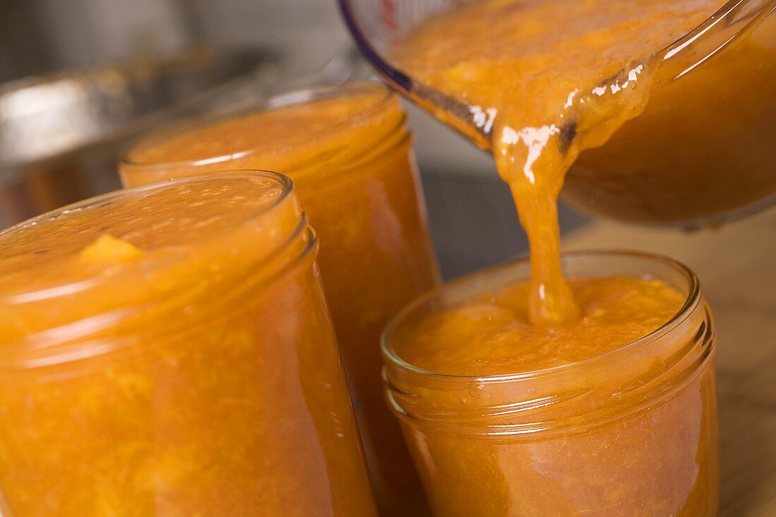 Pouring nectarine jam into jars