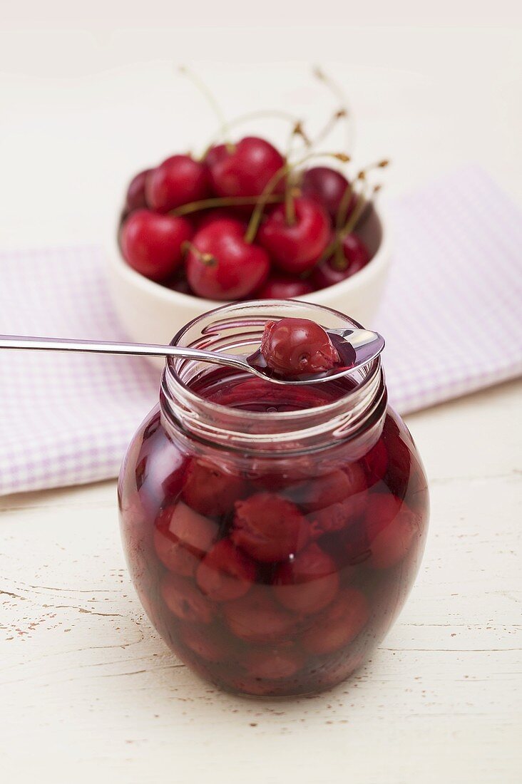 Cherry compote in jar and on spoon