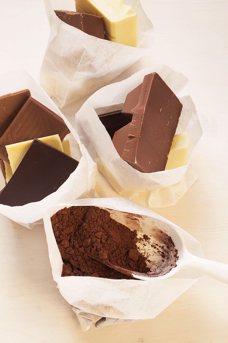Schokoladenstilleben mit Kakaopulver in Papiertüten