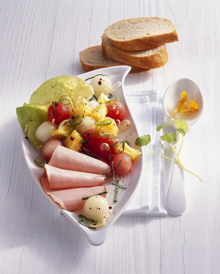 Savoury melon and pineapple salad with smoked, cured pork