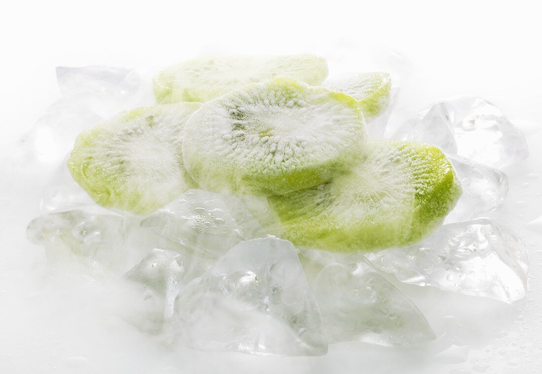 Frozen kiwi fruit slices on ice cubes