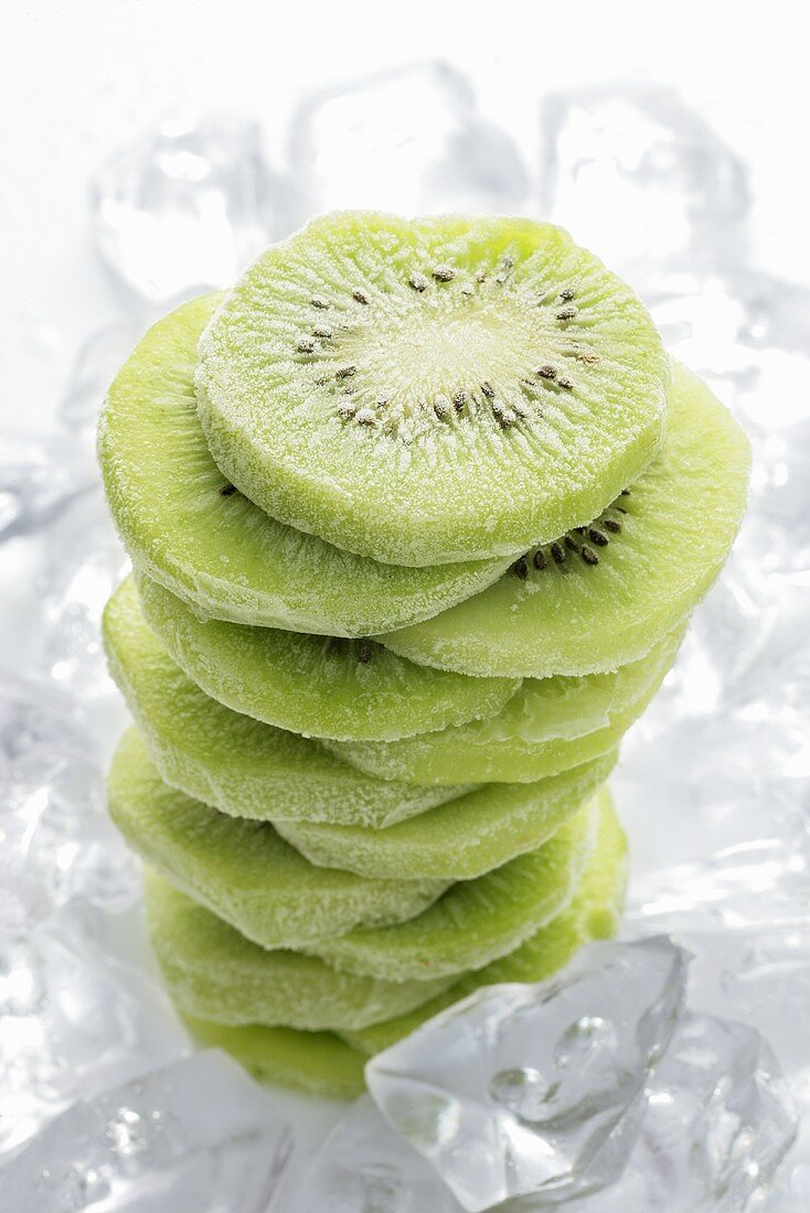 Frozen kiwi fruit slices (in a pile) on ice cubes