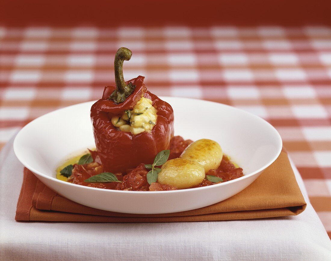 A stuffed pepper with tomato sauce and roast potatoes