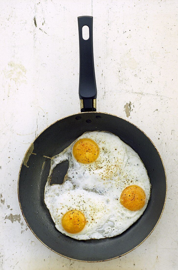 Three fried eggs in frying pan