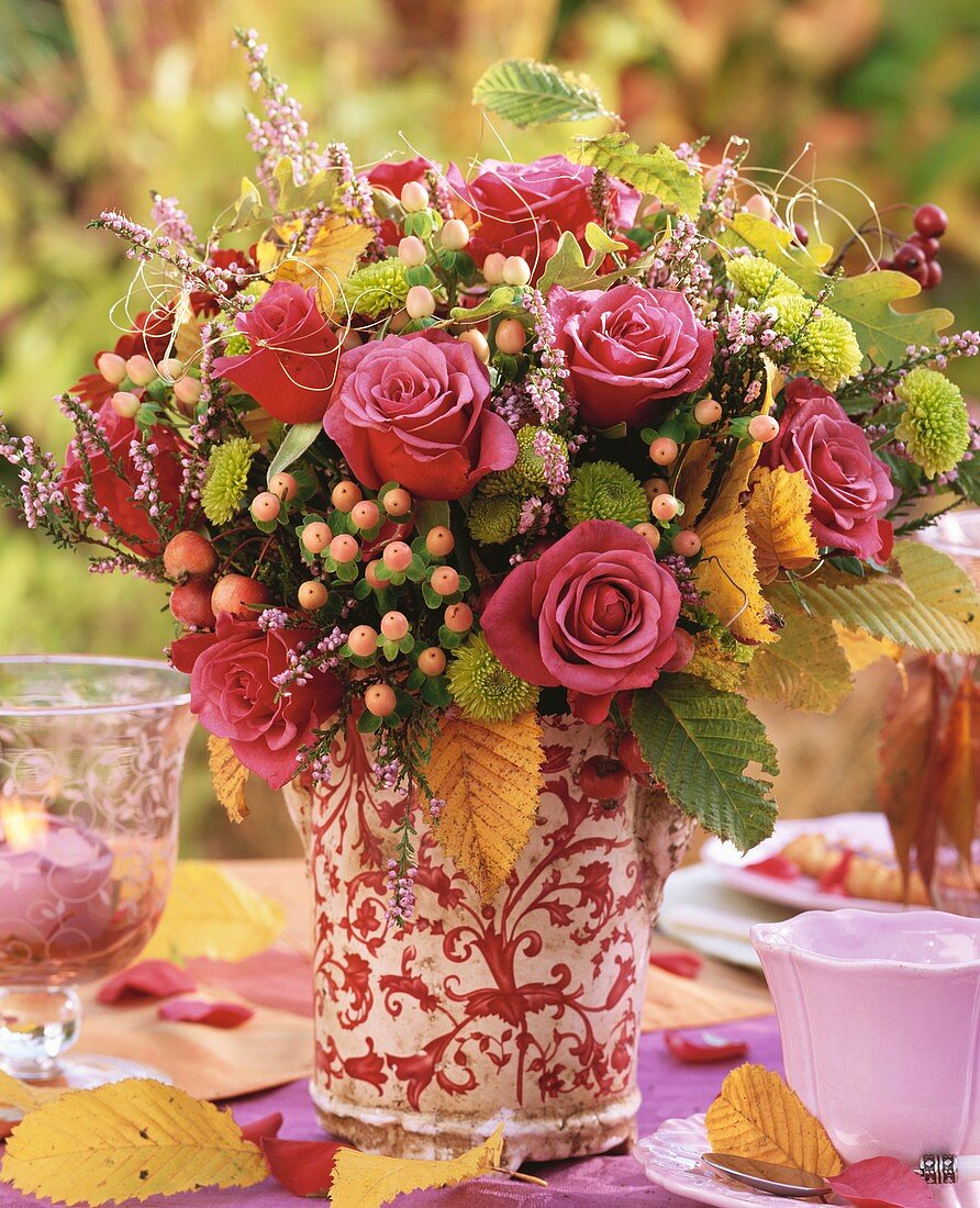 Vase of roses and autumn leaves