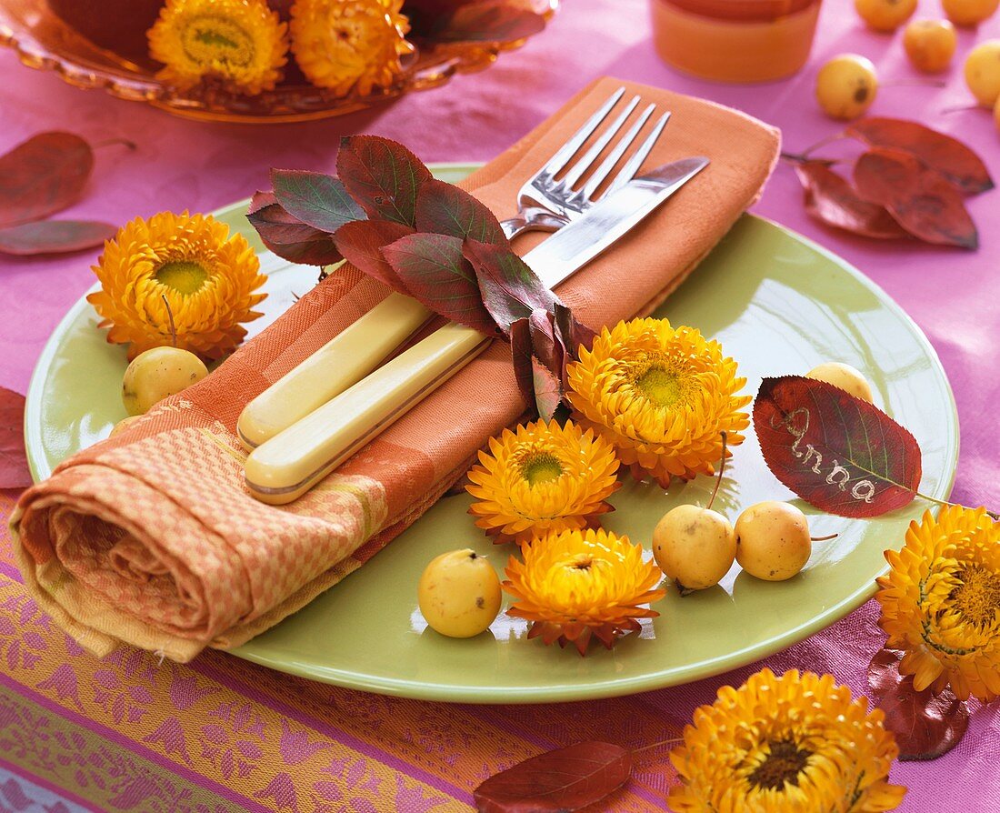Autumnal place-setting with strawflowers and leaves