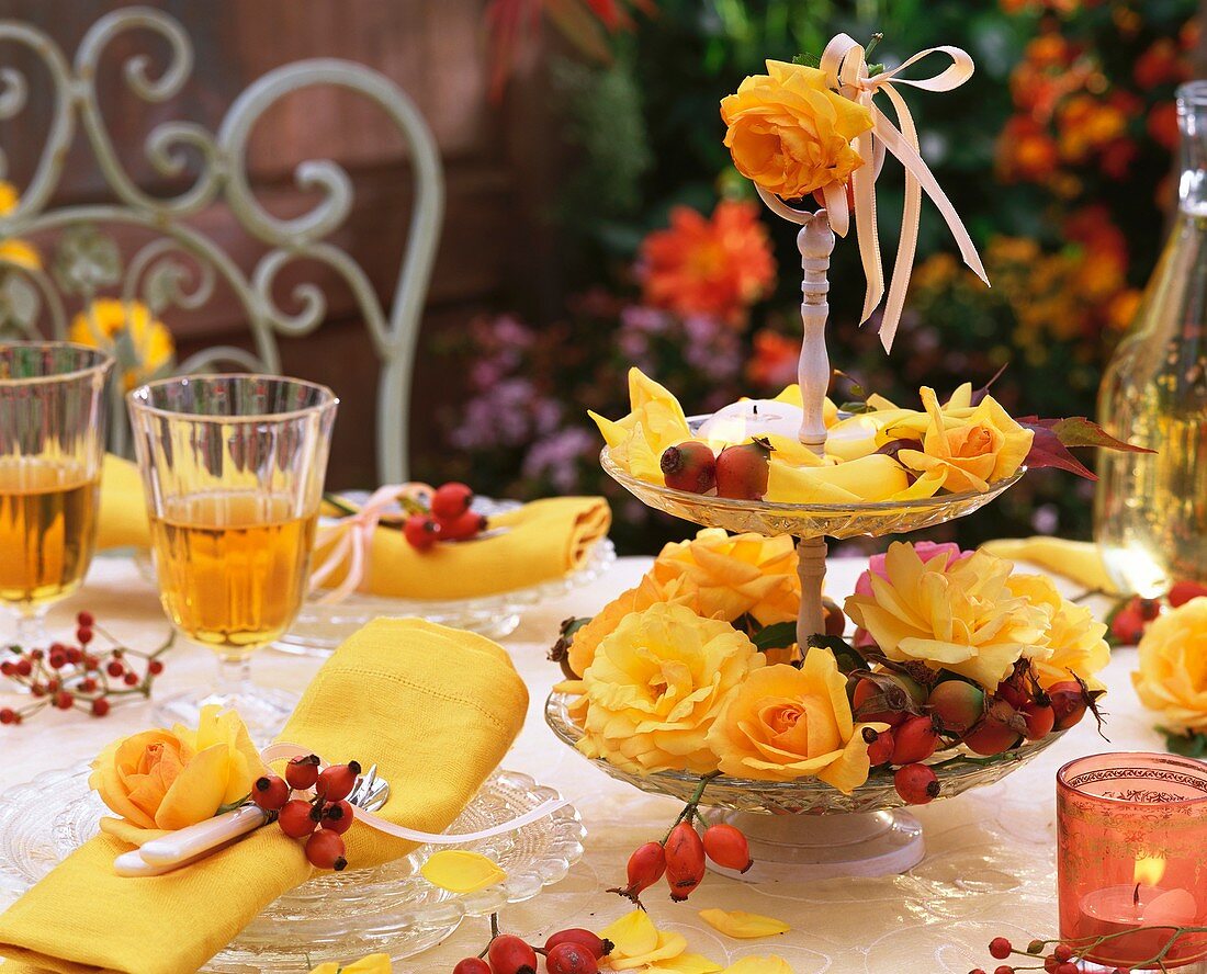 Herbstliche Tischdeko mit gelben Rosen und Hagebutten
