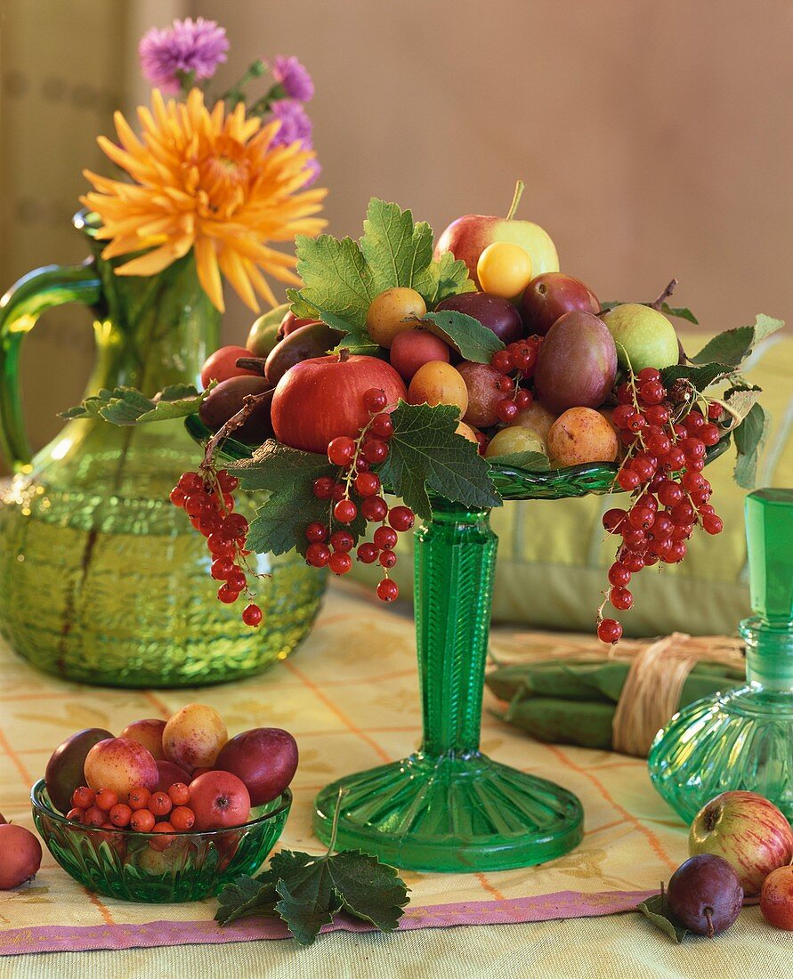 Apples, plums, mirabelles, redcurrants on glass stand