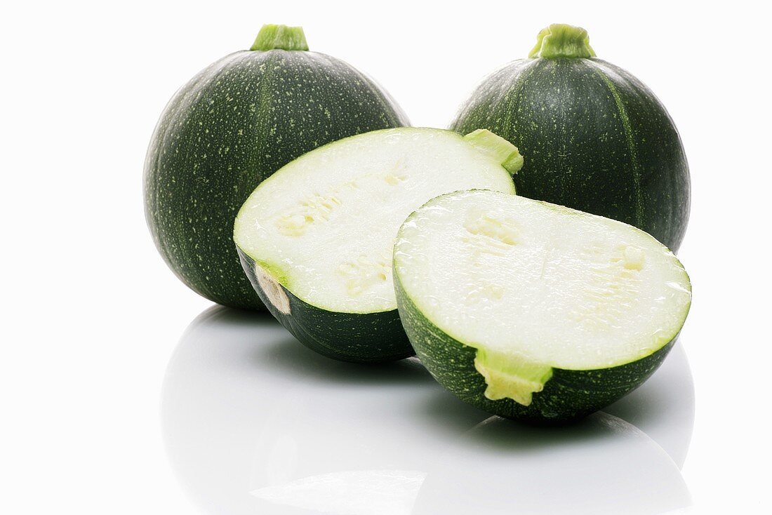 Three round courgettes, one halved