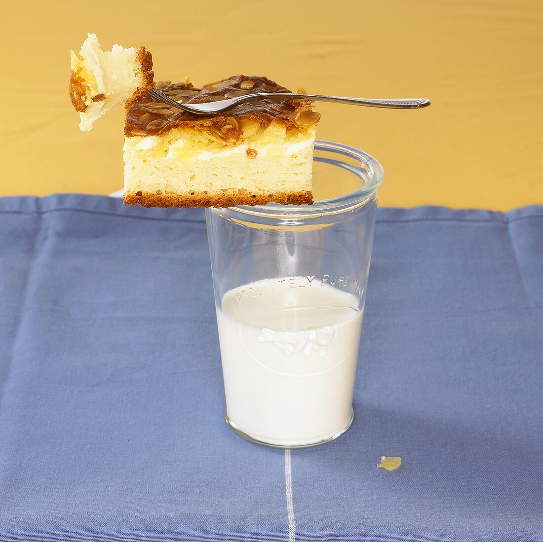 Piece of Eierschecke (egg custard cake) on glass of milk