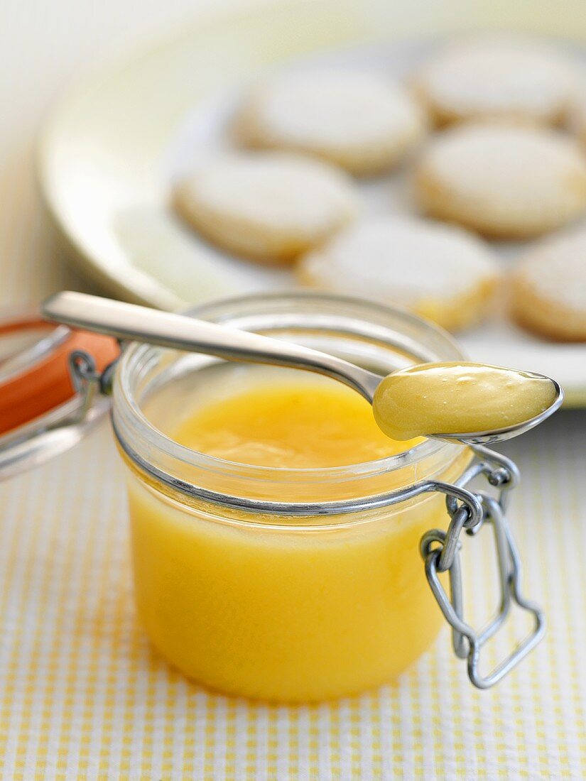 Lemon Curd im Glas und auf Löffel