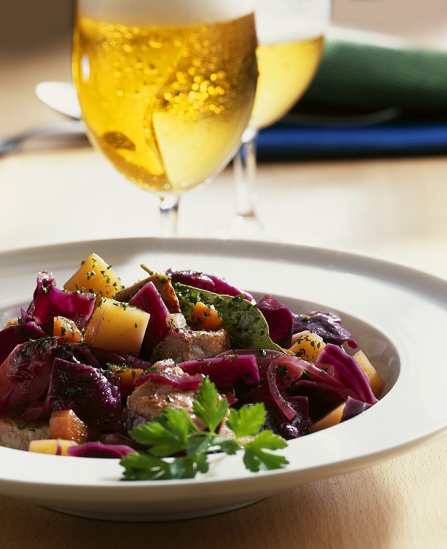 Pork and red cabbage stew, glasses of beer behind