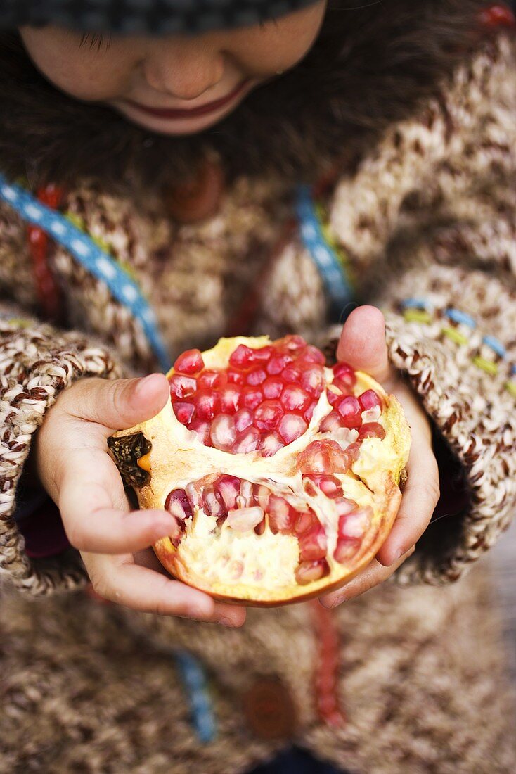 Child holding pomegranate