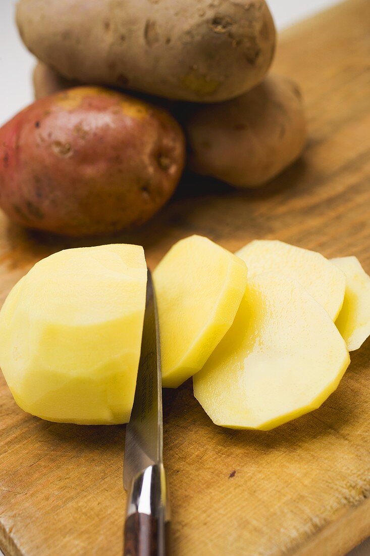 Peeled red potato, partly sliced