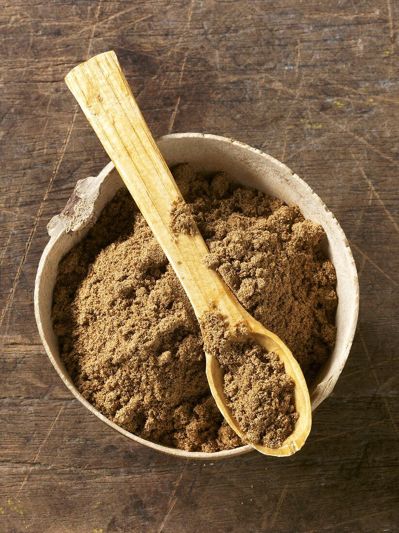 Garam masala in bowl and on wooden spoon
