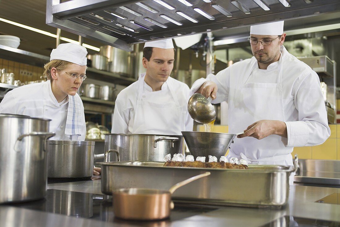 Chef ladling stock into a pan