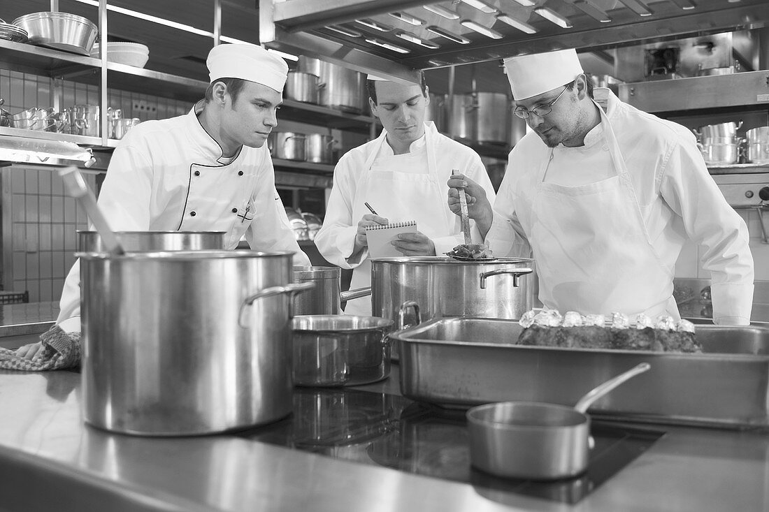 Three chefs checking cooked vegetables
