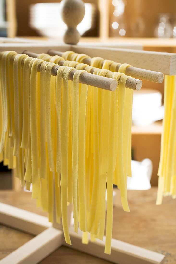 Home-made ribbon pasta hanging up to dry