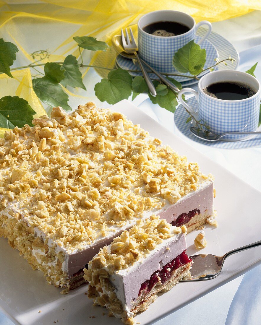 Cherry cream cake with rum and crumble, two cups of coffee