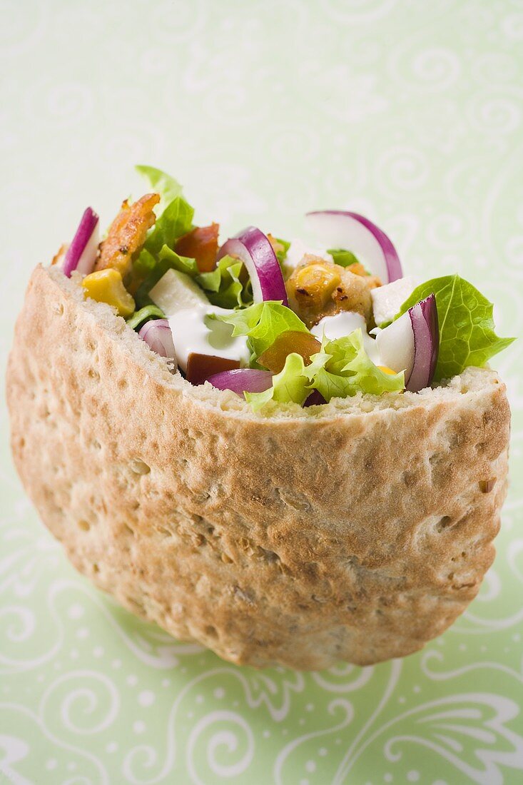 Gefülltes Brot mit Gemüse, Salat und Feta