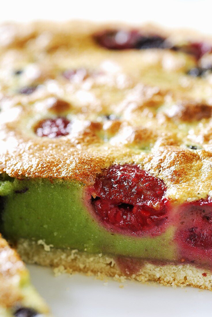 Pistachio fruit tart, a piece taken (close-up)