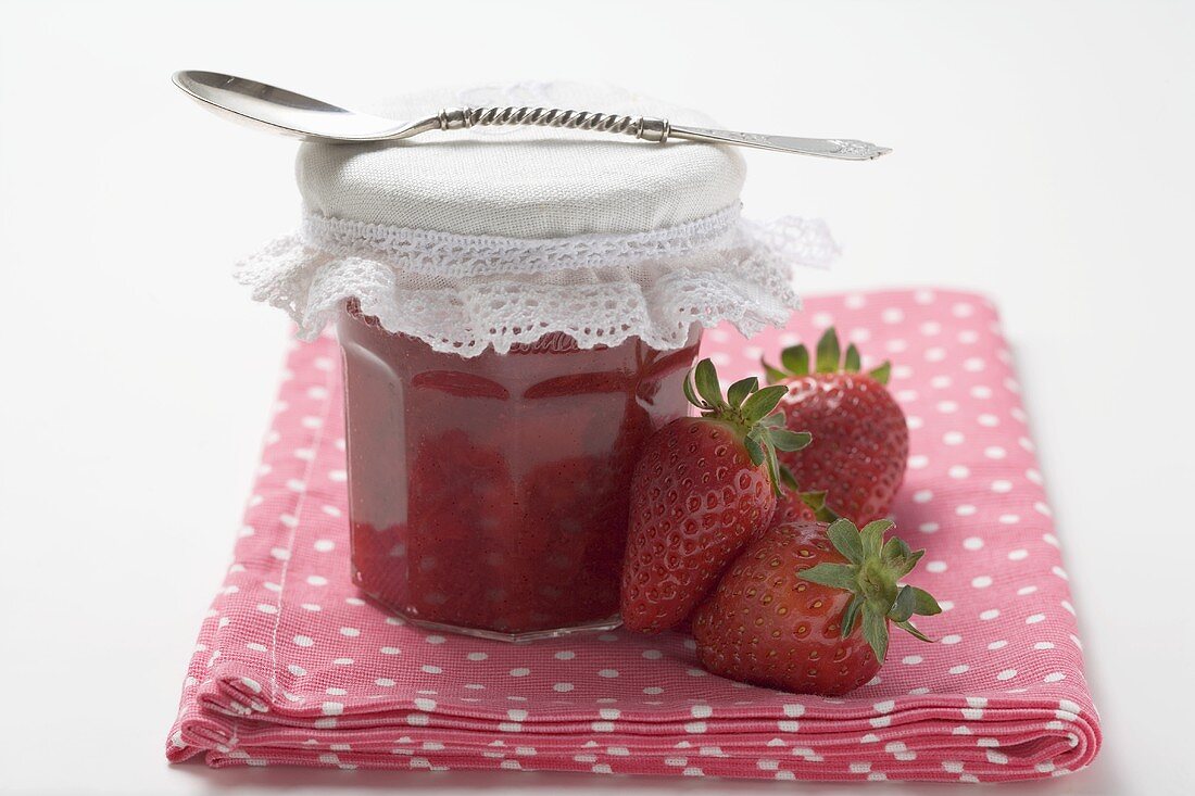 Glas Erdbeermarmelade und frische Erdbeeren