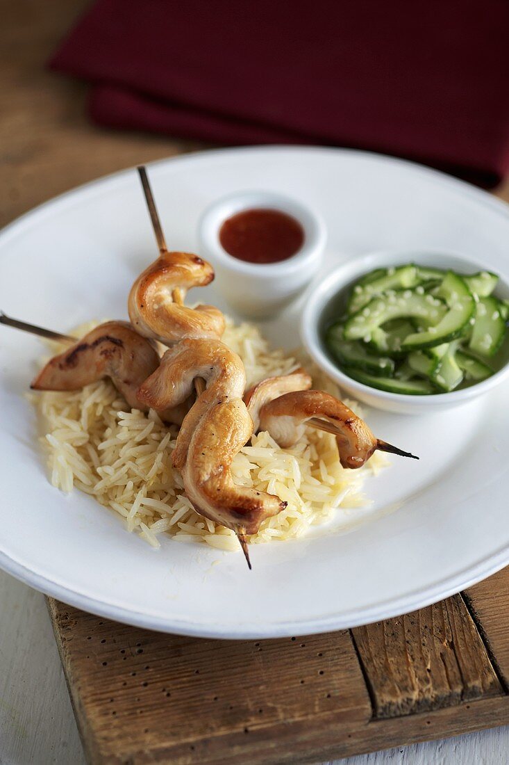Chicken kebabs on rice with cucumber salad