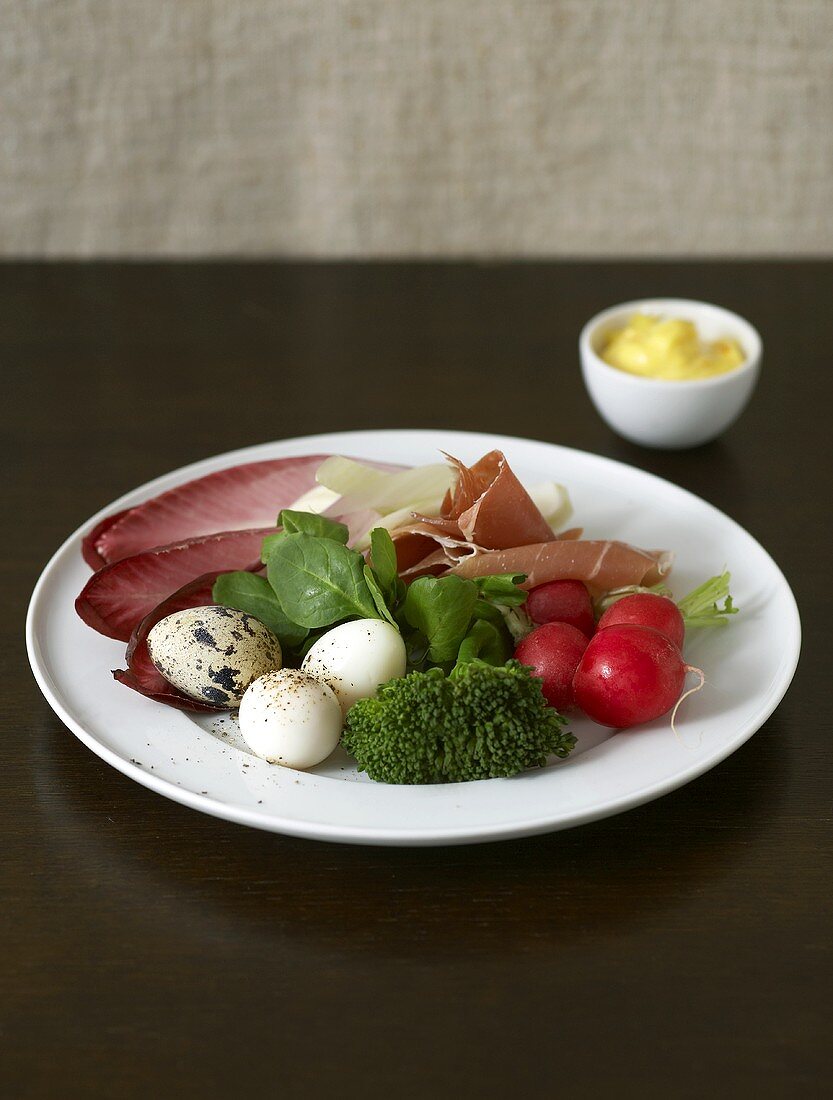 Plate of appetisers: quail's eggs, Parma ham, vegetables