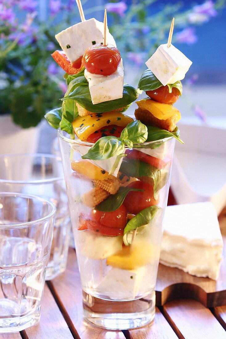 Skewered vegetables with cheese and basil in glass