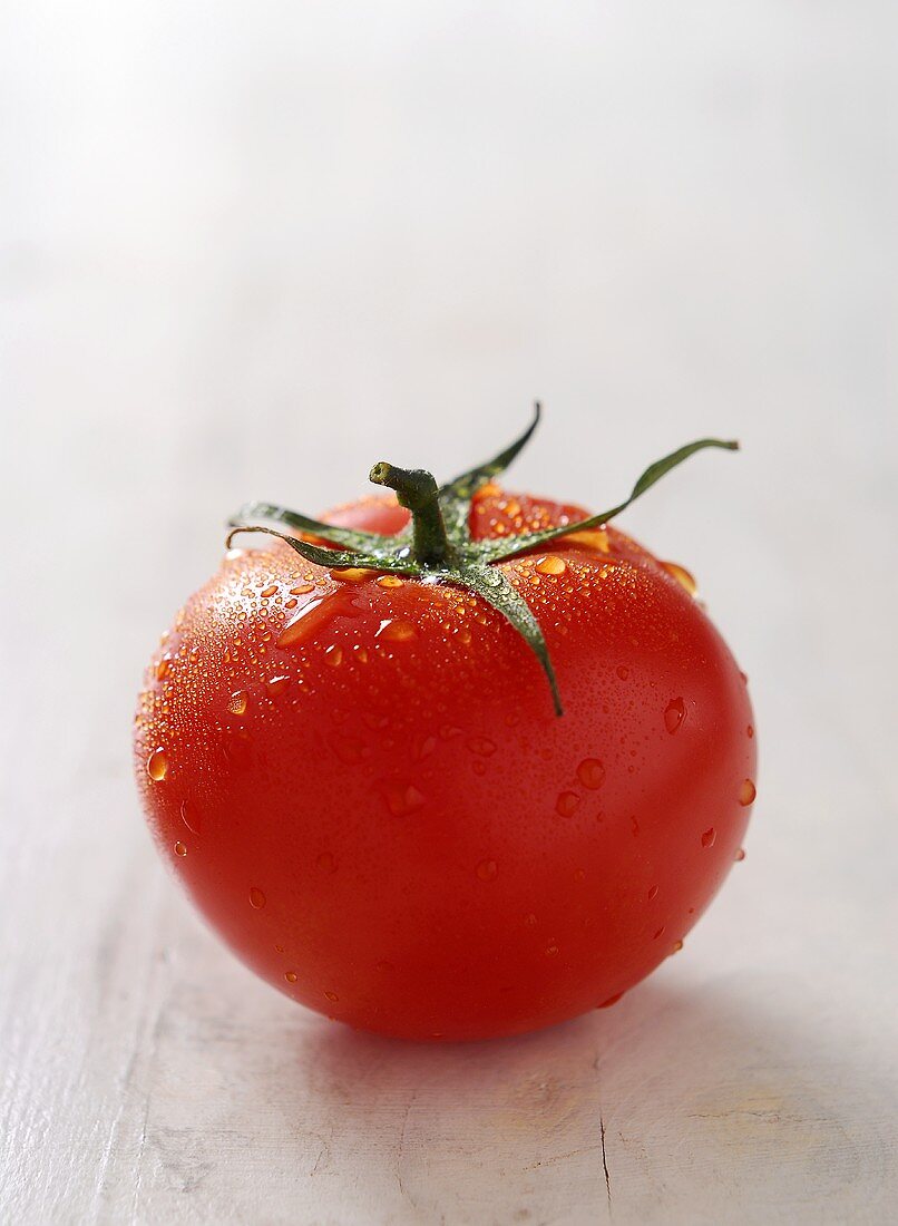 A tomato with drops of water