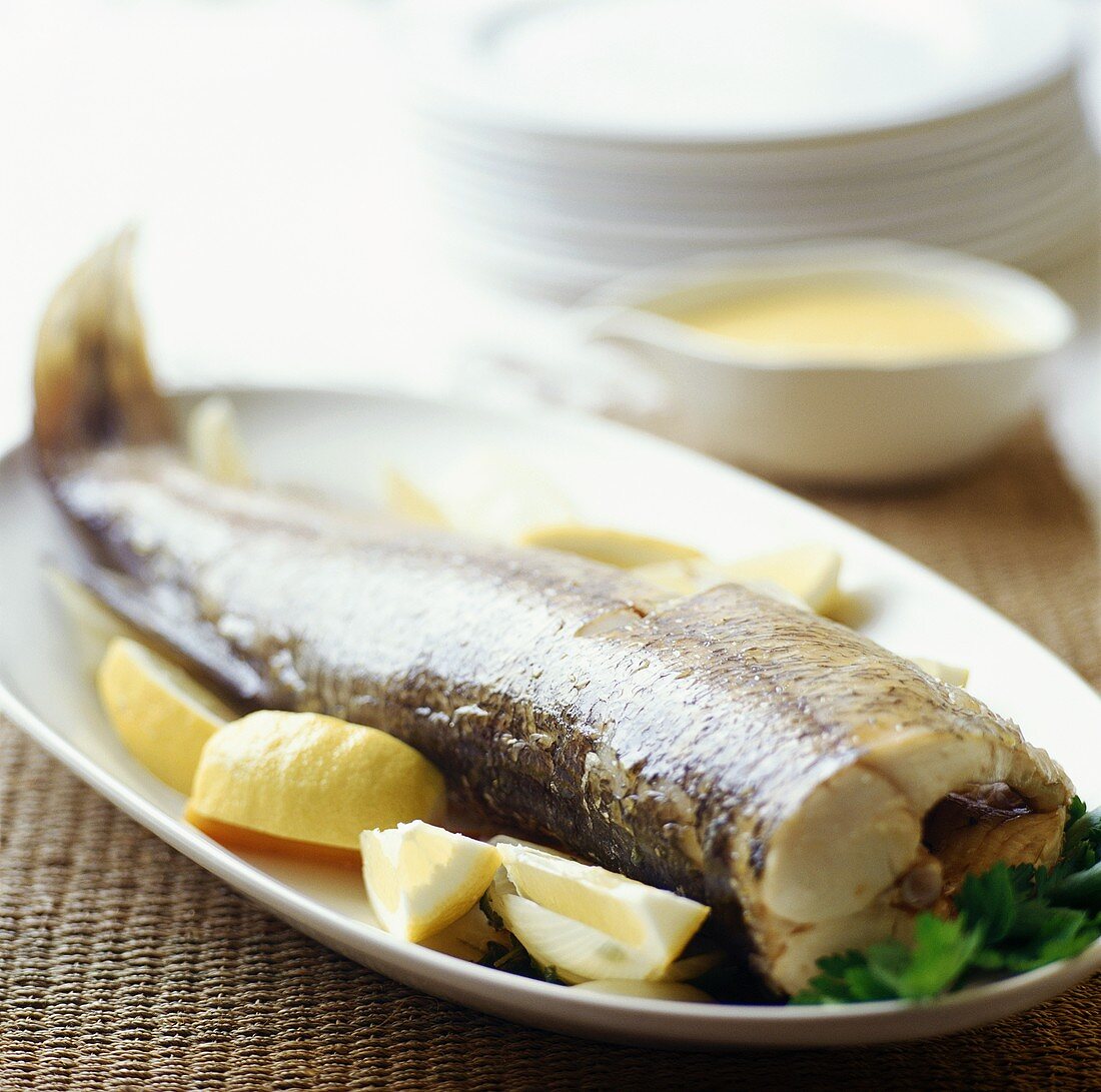 Cooked pike with lemons and butter sauce
