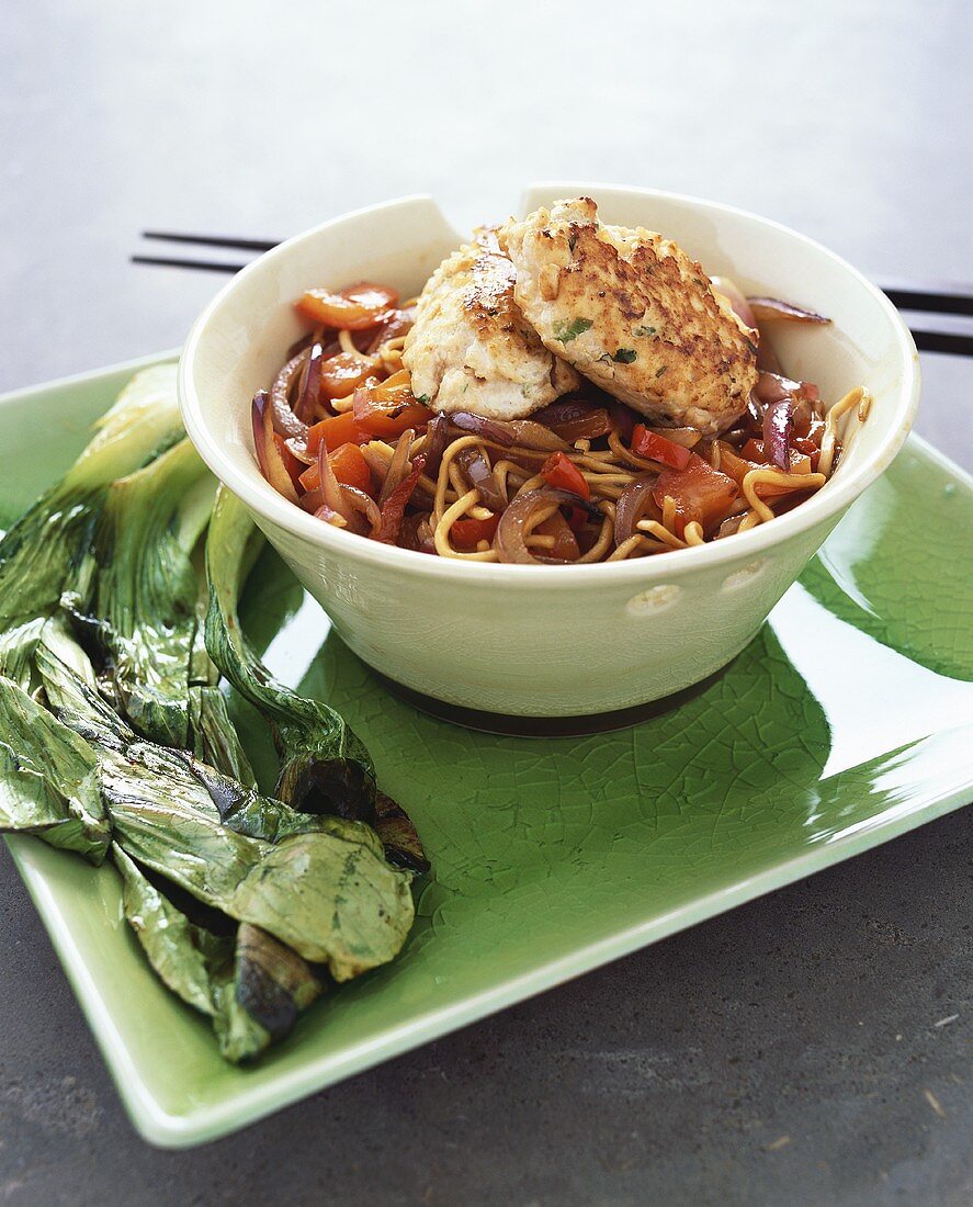 Fried noodles with salmon cakes and pak choi