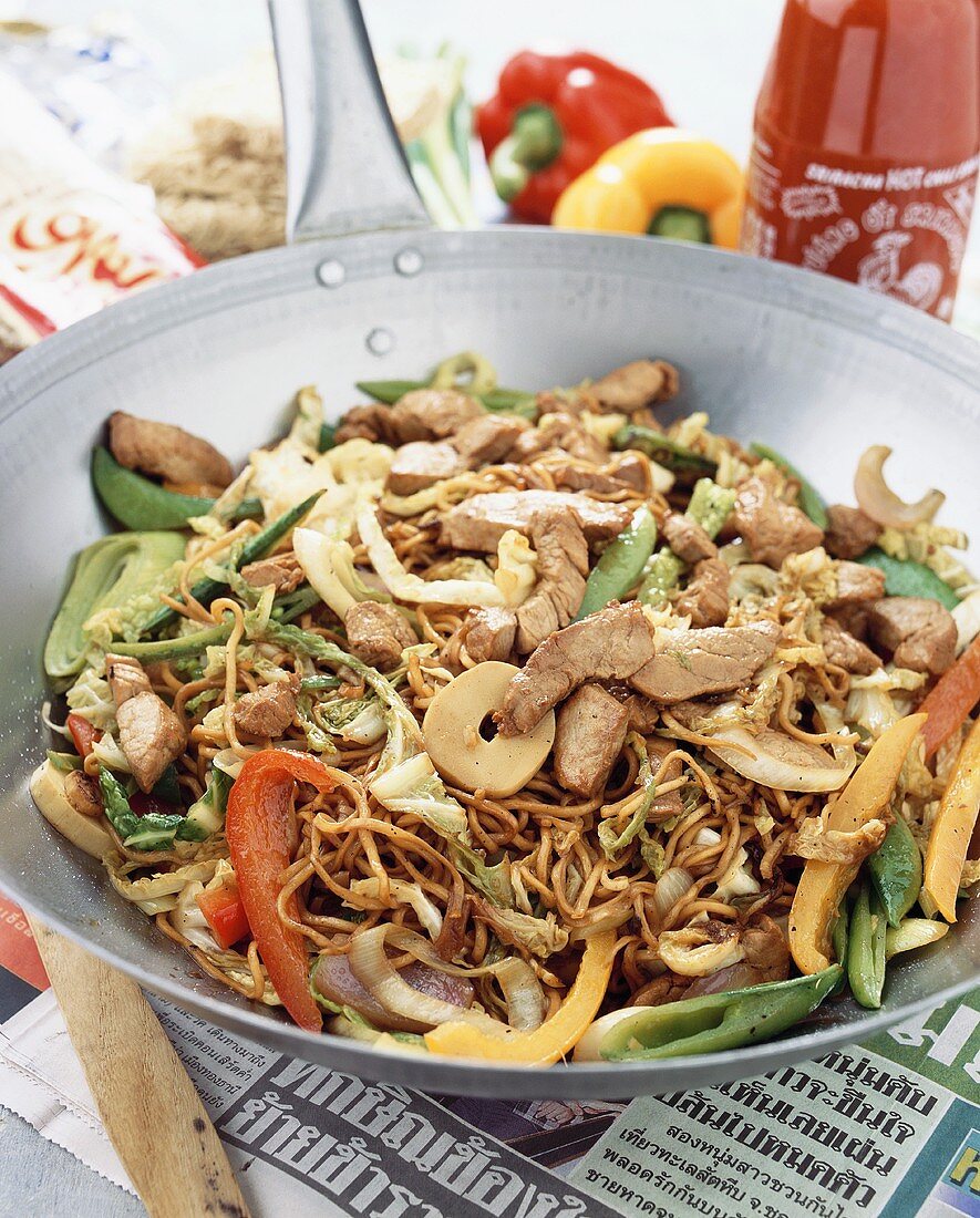 Fried noodles with meat and vegetables in wok (Thailand)