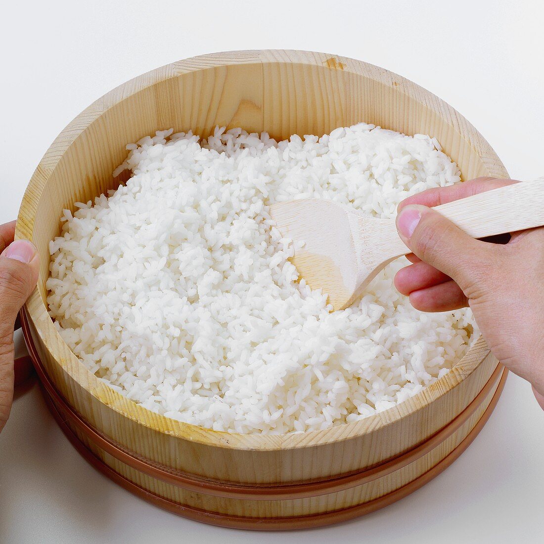 Making sushi rice (stirring with a wooden spoon)