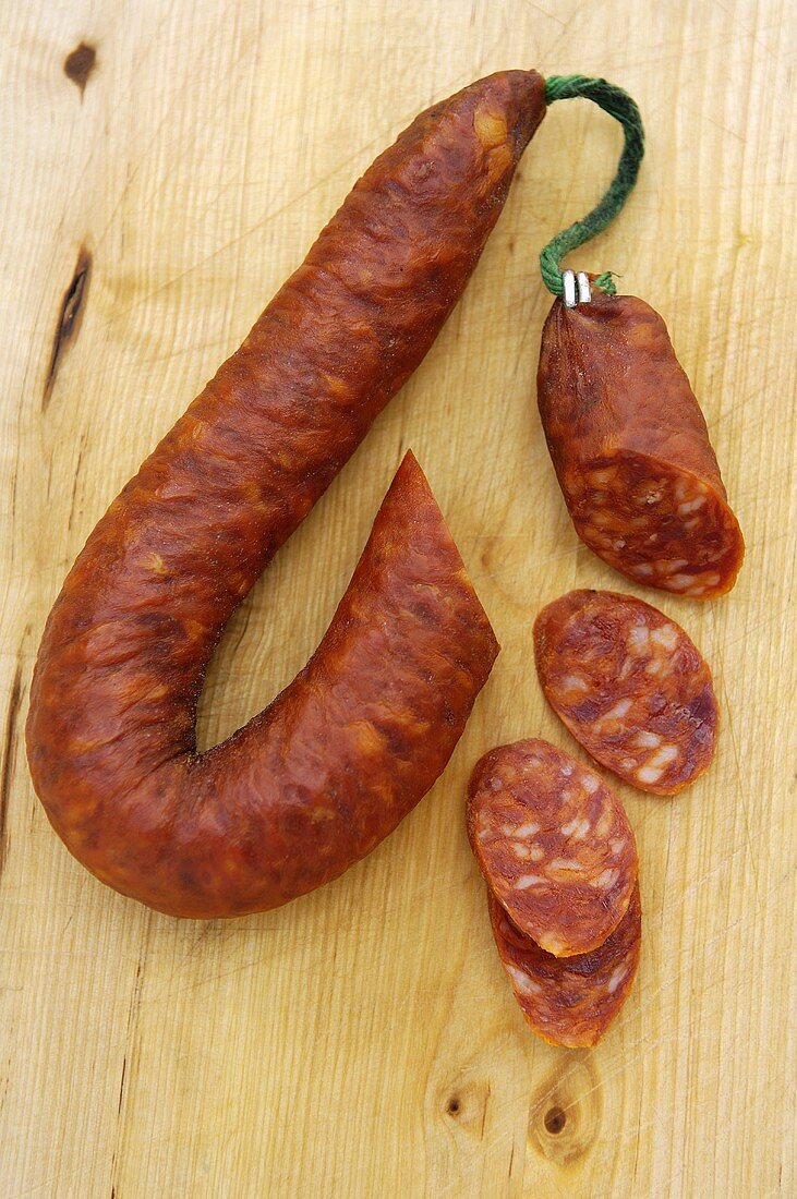 Chorizo auf Holzuntergrund, angeschnitten