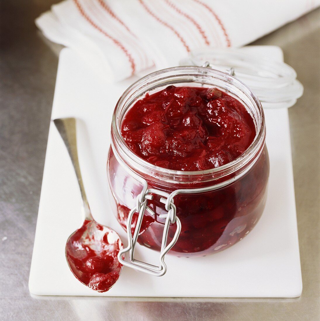 Cranberry relish in preserving jar, spoon beside it