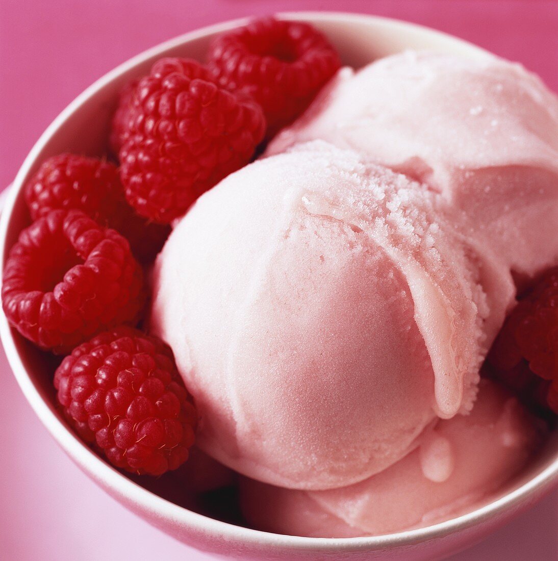 Raspberry ice cream with fresh raspberries in a bowl